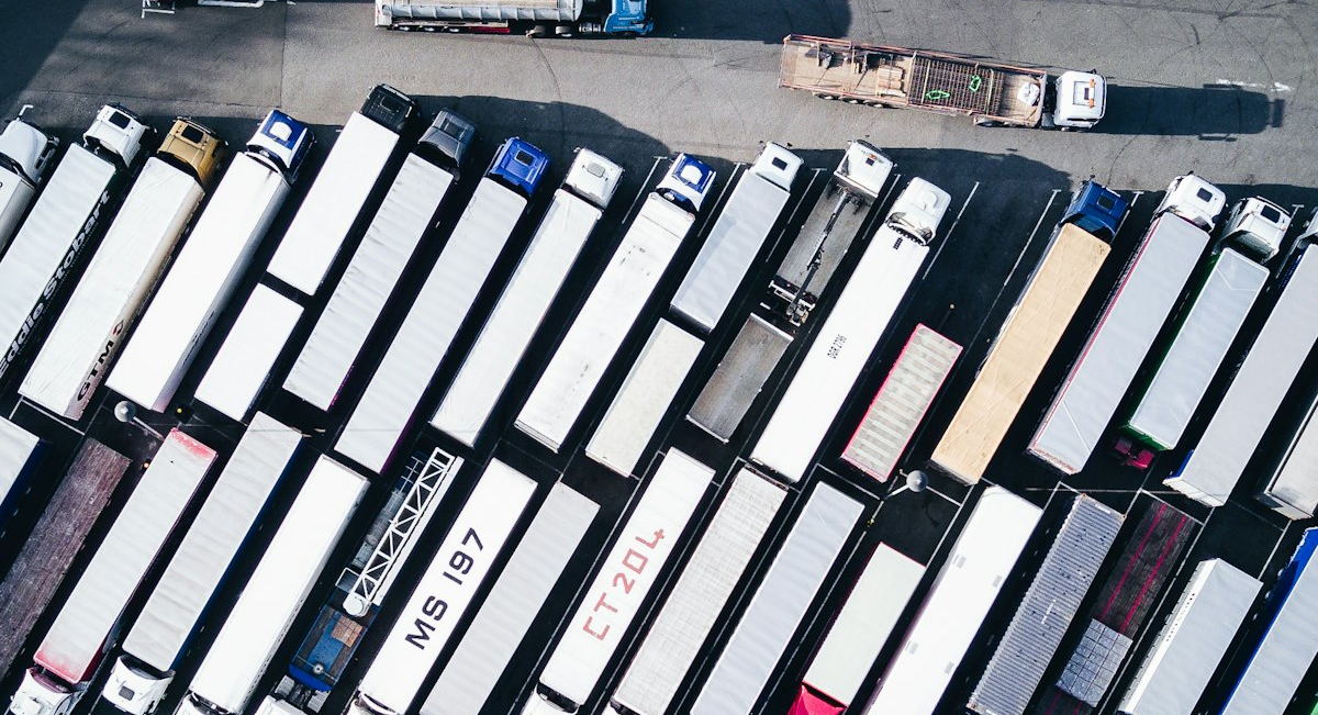 Vista aérea de um pátio com veículos de entrega estacionados em fileira